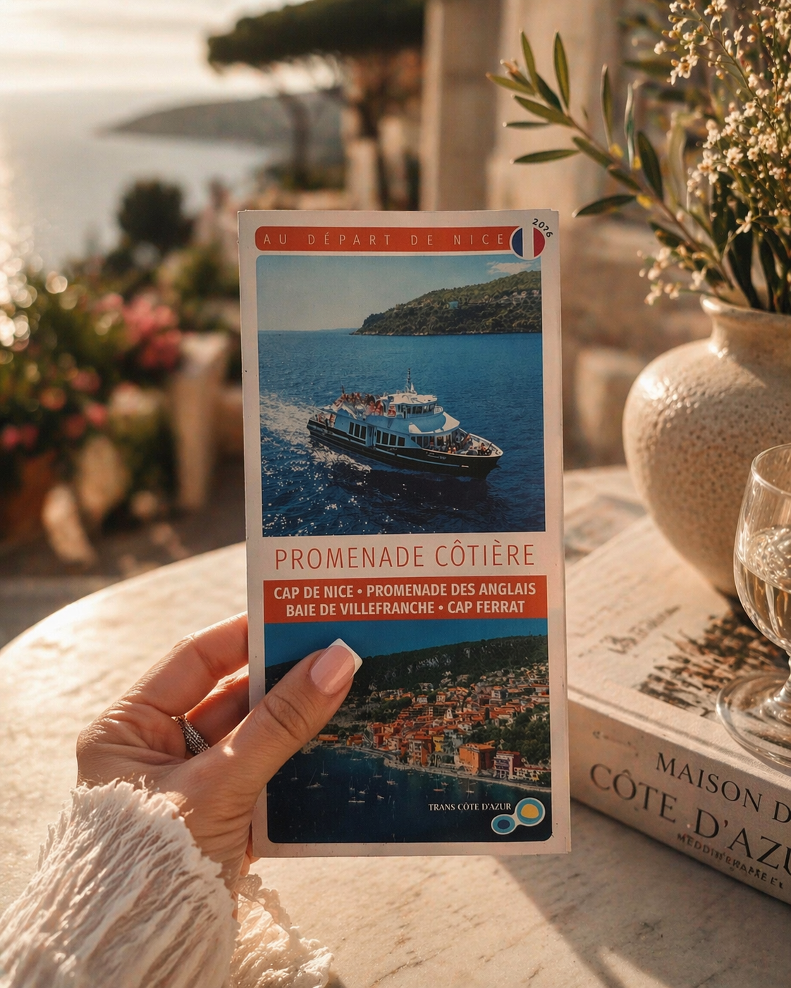 Brochure éditoriale tenue en main au soleil, ambiance Riviera